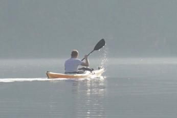Ein Paddler im Kajak auf ruhigem Wasser